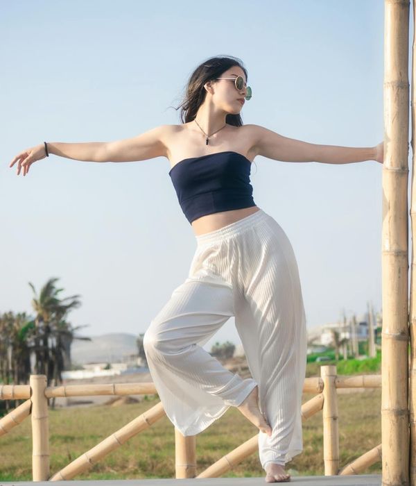 Woman in a graceful yoga pose with light blue accents.